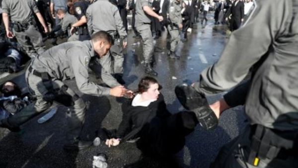 عناصر من الشرطة الاسرائيلية يحاولون ابعاد يهودي من المتدينين من احد شوارع القدس خلال تظاهرة ضد الخدمة العسكرية الالزامية

