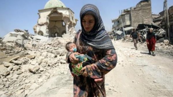 امرأة عراقية تفر من المدينة القديمة في الموصل في 5 تموز/يوليو 2017 خلال العمليات العراقية لاستعادة المدينة.

