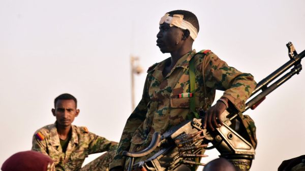 جنود من الجيش السوداني يتابعون احتجاجا يطالب بتنحي الرئيس عمر البشير أمام وزارة الدفاع في الخرطوم

