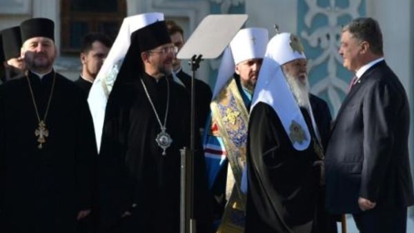 الرئيس الاوكراني يصافح البطريرك فيلاريت اثناء القداس في كييف الاحد
