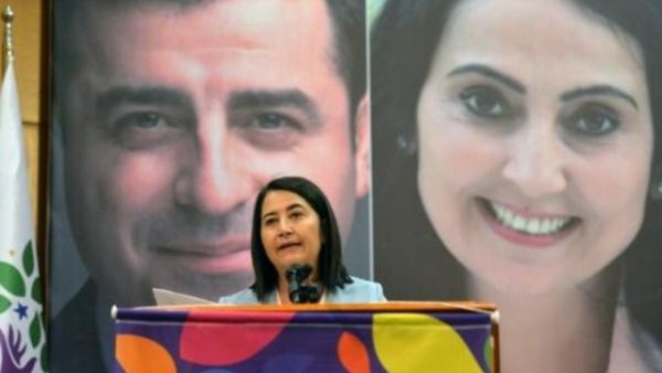 سيربيل كمال بيه الرئيسة المشاركة المنتخبة لحزب الشعوب الديموقراطي المعارض تتحدث امام صورة زعيمي الحزب المسجونين فيغن يوكسيكداغ وصلاح الدين دمرتاس

