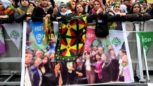 متظاهرون اكراد في كولونيا خلف صورة للسياسيين الاكراد الموقوفين

