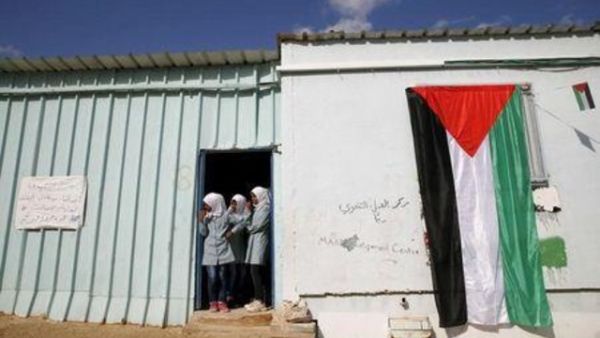 فتيات فلسطينيات ينظرن من بيوت متنقلة تستخدم كمدارس في الضفة الغربية
