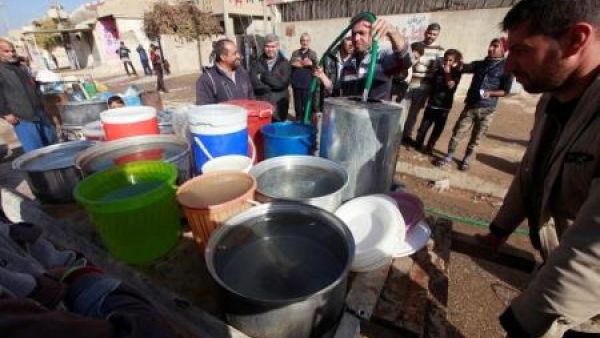 عراقيون يحصلون على الماء في الموصل بشمال العراق
