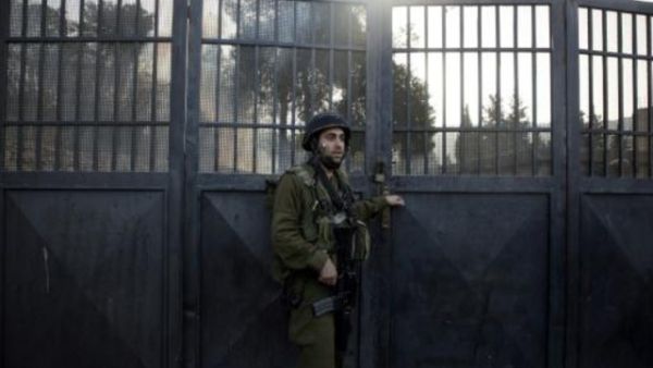 جندي اسرائيلي يقف عند مدخل المدرسة
