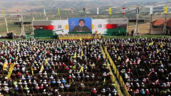 الأمين العام لجماعة حزب الله اللبنانية حسن نصر الله يخاطب تجمعا لمناصريه عبر شاشة عملاقة في إحدى القرى في جنوب لبنان بالقرب من الحدود مع إسرائيل يوم الجمعة
