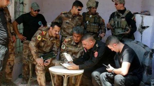 ضباط بالجيش العراقي يشاهدون شريطا مصورا نقلته طائرة بدون طيار على خط الجبهة في الموصل القديمة

