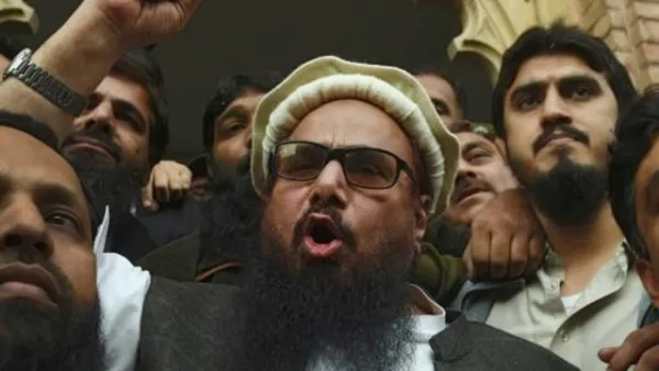 رجل الدين المتشدد حافظ سعيد يتحدث إلى الصحافيين خارج محكمة في باكستان عقب الأمر بإطلاق سراحه
