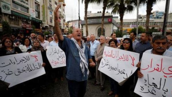 فلسطينيون يشاركون في احتجاج يطالب برفع "الإجراءات العقابية عن غزة" في رام الله يوم الثلاثاء

