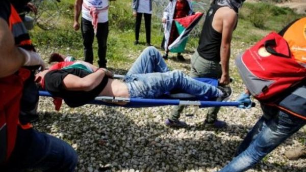 فلسطينيون ينقلون متظاهرا جريحا خلال مواجهات في قرية بلعين قرب الجدار الفاصل في الضفة الغربية المحتلة
