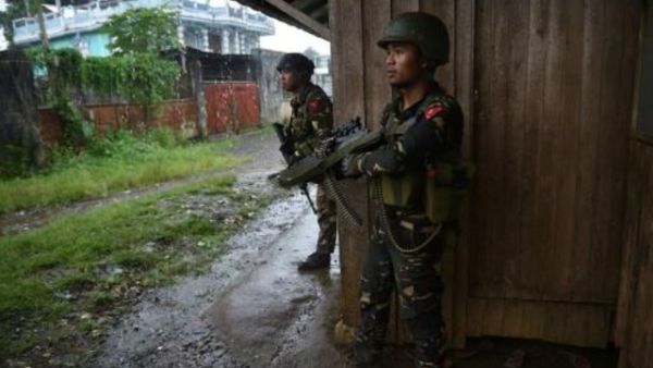 قوات فيليبينية تتمركز في مواجهة قناصة في أثناء مواكبتها عمالا وسكانا علقوا وسط الاشتباكات بين الجيش ومقاتلين جهاديين في مدينة مراوي في جزيرة منداناو
