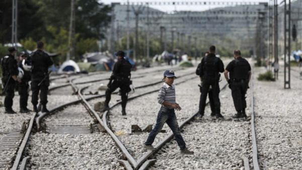 A boy walks acros rail tracks during a police operation to clear a makeshift camp for refugees and migrants at the border between Greece and Macedonia near the village of Idomeni, northern Greece on May 25, 2016. (AFP/Yannis Kolesidis)