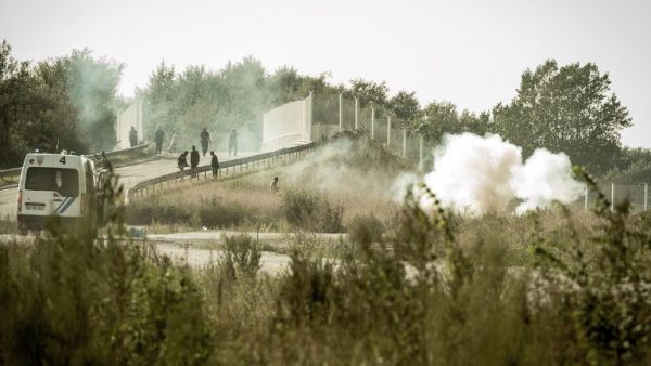 Riot police disperse migrants and refugees trying to get into trucks heading to Great Britain, on September 21, 2016 in Calais. (AFP/Philippe Huguen)