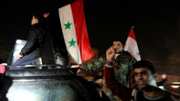أنصار الرئيس السوري بشار الأسد يحملون اعلامهم الوطنية ويحتفلون بما اعتبروه انتصار الجيش السوري في حلب يوم الاثنين
