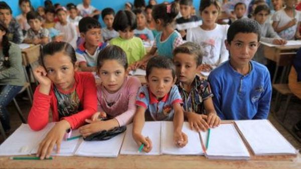 أطفال يحضرون حصتهم الأولى بعد تسجيلهم مباشرة في مدرسة في حزيمة بشمال الرقة بسوريا
