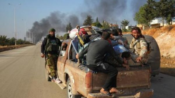 مقاتلون من المعارضة السورية على متن سيارة مع مدنيين فارين من ضاحية بغرب حلب 

