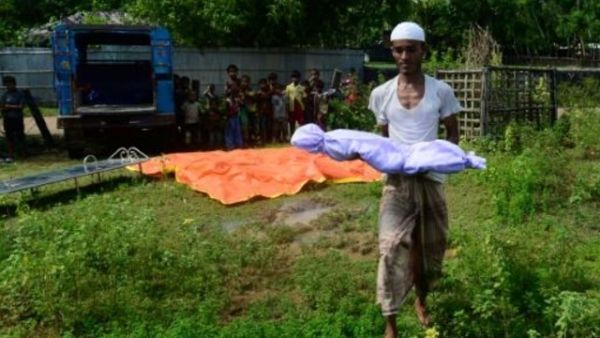 متطوع بنغلادشي يحمل جثة طفل من الروهينغا قضى في غرق مركب

