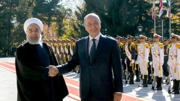 الرئيس الإيراني حسن روحاني (يسار) مصافحا نظيره العراقي برهم صالح خلال مراسم استقباله في طهران

