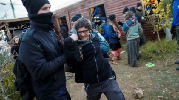 رجل امن اسرائيلي يبعد مستوطنة يهودية بالقوة خلال اخلاء بؤرة عمونا الاستيطانية شمال شرق رام الله
