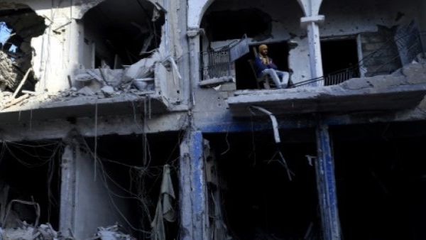 يجلس على شرفة مبنى مدمر في الرقة السورية التي استعادها مقاتلون غالبيتهم من الاكراد من ايدي تنظيم الدولة الاسلامية الخريف الماضي
