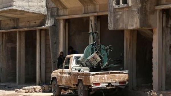 مقاتل بالجيش السوري الحر يقف بجوار سيارة مثبت عليها مدفع مضاد للطائرات في القنيطرة
