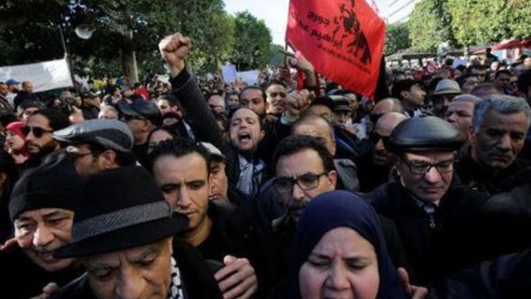 أشخاص يهتفون أثناء مظاهرات في الذكرى السابعة للإطاحة بالرئيس السابق زين العابدين بن علي في تونس يوم الأحد
