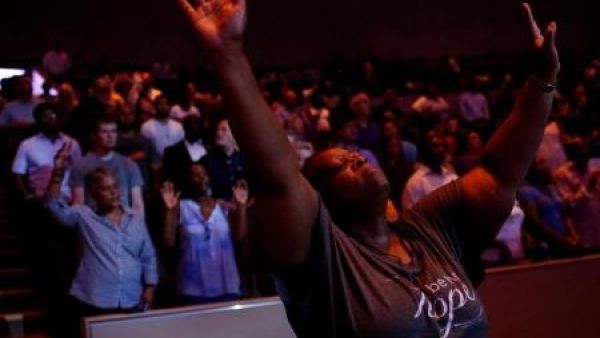 أناس يقفون أثناء قداس لأفراد الشرطة في كنيسة في دالاس بولاية تكساس
