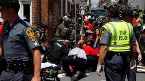 عمال إنقاذ يساعدون أناس أصيبوا بعد أن دهستهم مركبة في أحد شوارع مدينة تشارلوتسفيل بولاية فرجينيا الأمريكية يوم السبت

