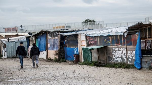People walk in the main street of the ''Jungle'' migrant camp where all makeshift shops have closed as French Interior Minister said on the eve the demolition of the camp would take place "within days" on October 19, 2016. (AFP/Denis Charlet)
