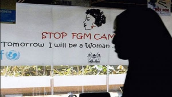 A woman walks past a poster from a campaign to stop FGM in Egypt. (AFP/File)