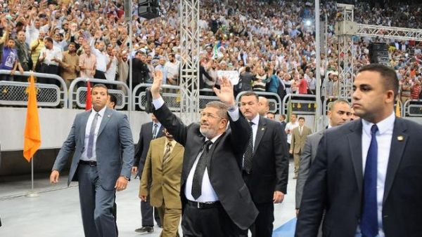 Egyptian President Mohammed Morsi (C) waves at thousands of Islamist supporters as he arrives for the "Support for Syria" rally at a Cairo stadium on June 15 (Egyptian Presidency / AFP)