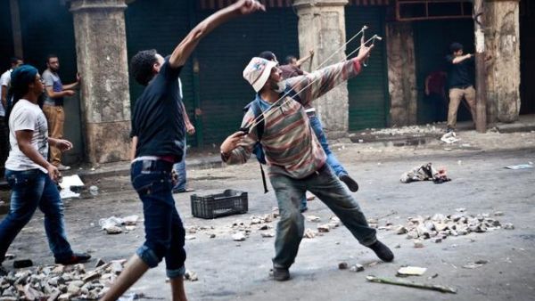 EGYPT, Cairo : Supporters of ousted president Mohamed Morsi throw stones as they clash with security officers in Cairo's Ramses Square, on August 16, 2013. AFP PHOTO / VIRGNIE NGUYEN HOANG