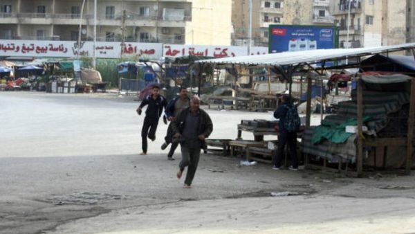 People run for cover from sniper fire in the Lebanese northern coastal city of Tripoli on December 1, 2013. [AFP]