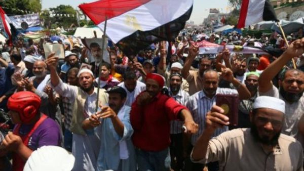 رفع الطلاب خلال الوقفة فجر الثلاثاء، شارات رابعة العدوية، كما رددوا هتافات مناهضة لما يصفونه بـ”الانقلاب العسكري”