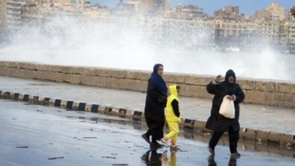 مصريون يمرون بجانب شاطئ في الاسكندرية بعد الامطار الغزيرة التي شهدتها المدينة