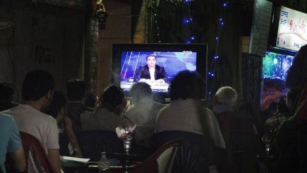 A file picture shows Egyptians watching comedian Bassem Youssef's show as they sit at a public coffee shop.  (Image credit: AFP)