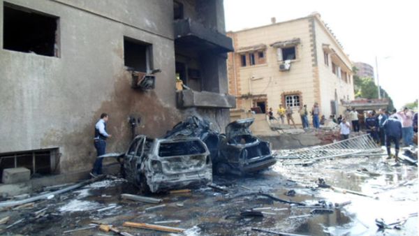People look at burnt vehicles after a car bomb attack outside a military intelligence building that wounded four people on October 19, 2013 in Egypt's canal city of Ismailia. (Image credit: AFP)