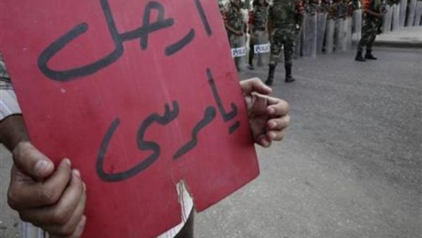 متظاهر يحمل لافتة ضد الرئيس المصري محمد مرسي بالقرب من دار الحرس الجمهوري في القاهرة 