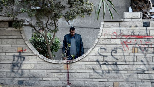 An Egyptian policeman inspects the site of a bomb blast in Cairo on 24 March 2017. (AFP/Mohamed al-Shahed)