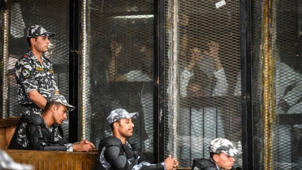 Members of Egypt's banned Muslim Brotherhood are seen inside a glass dock during their trial in the capital Cairo on July 28, 2018. (AFP/Khaled Desouki)