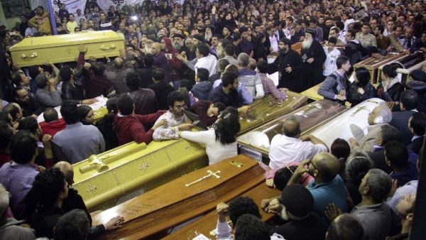 Egyptian Christians gather around and carry coffins during the late night funeral of the victims of a blast which killed worshippers attending Palm Sunday mass at the Mar Girgis Coptic Orthodox Church in the Nile Delta City of Tanta, 75 miles north of Cairo, on April 9, 2017. (AFP/Stringer)