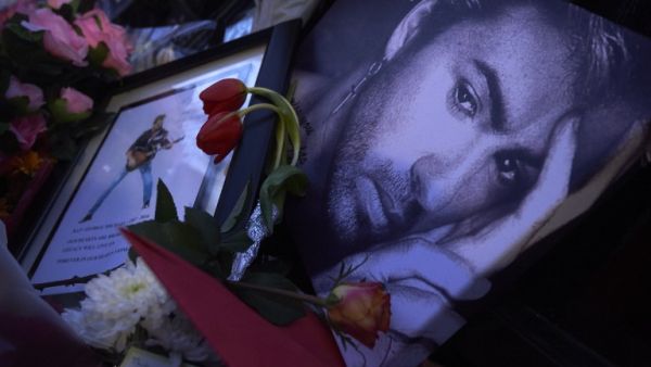 A message bearing a portrait of late British singer George Michael is seen amid flowers, candles and other messages left by well-wishers in tribute outside the singer's home in north London on December 27, 2016. (AFP/Niklas Halle'n)