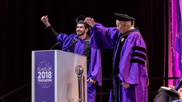 Fouad Hassan, the student speaker at NU-Q’s graduation ceremony, and Dean Everette E. Dennis perform the Northwestern Wildcat cheer.