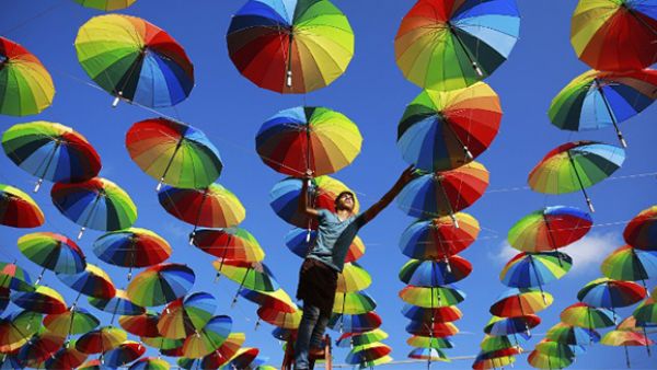 A Palestinian worker of a beachside coffeehouse decorates its terrace with hanging colourful umbrellas as part of decorations for the Muslim holy fasting month of Ramadan in Gaza. (AFP/File)