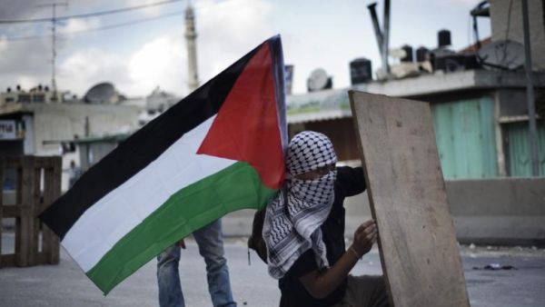 A Palestinian man takes cover at Qalandiya checkpoint between Ramallah and Jerusalem on September 23, 2011.  (AFP/Alessio Romenzi)