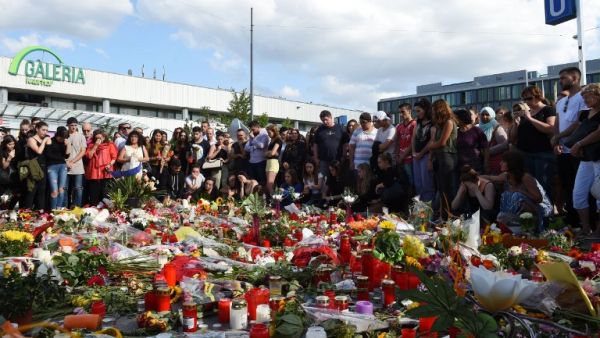 People mourn at a memorial on July 24, 2016 in front of the Olympia Einkaufszentrum shopping center in Munich, Germany, where an 18-year-old German-Iranian student shot and killed nine people. (AFP/Christof Stache)