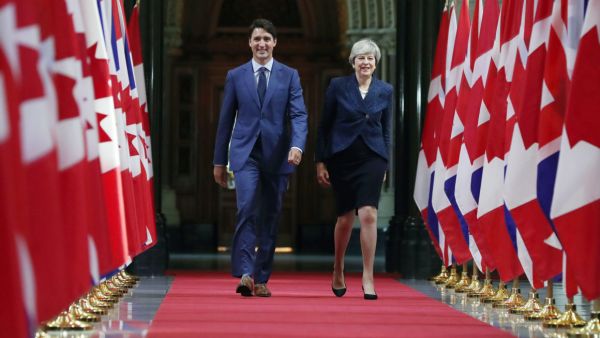 Canadian Prime Minister Justin Trudeau and British Prime Minister Theresa May walk down the Hall of Honour in Ottawa, Ontario (AFP/File Photo)	