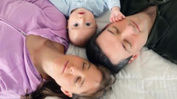 صورة تعبيرية لطفل رضيع بين والديه
