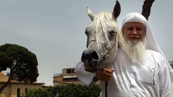 A competitor poses with his horse during a show of Arab horses at the Beirut Hippodrome. (AFP/File)