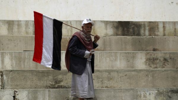 A Houthi man carries a Yemeni flag in the capital city, Sanaa. (AFP/Mohammed Huwais)